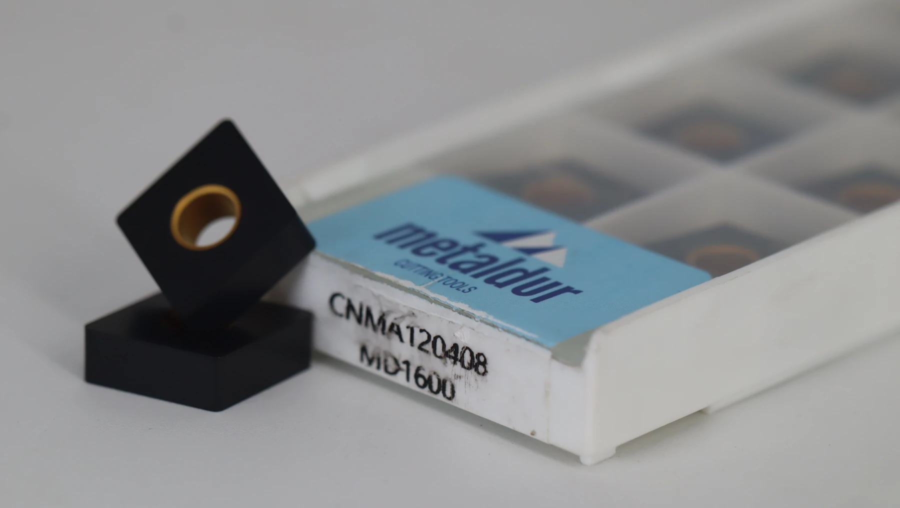 A full box of inserts with three laid out in front, the label reading APMT1604 MD2725