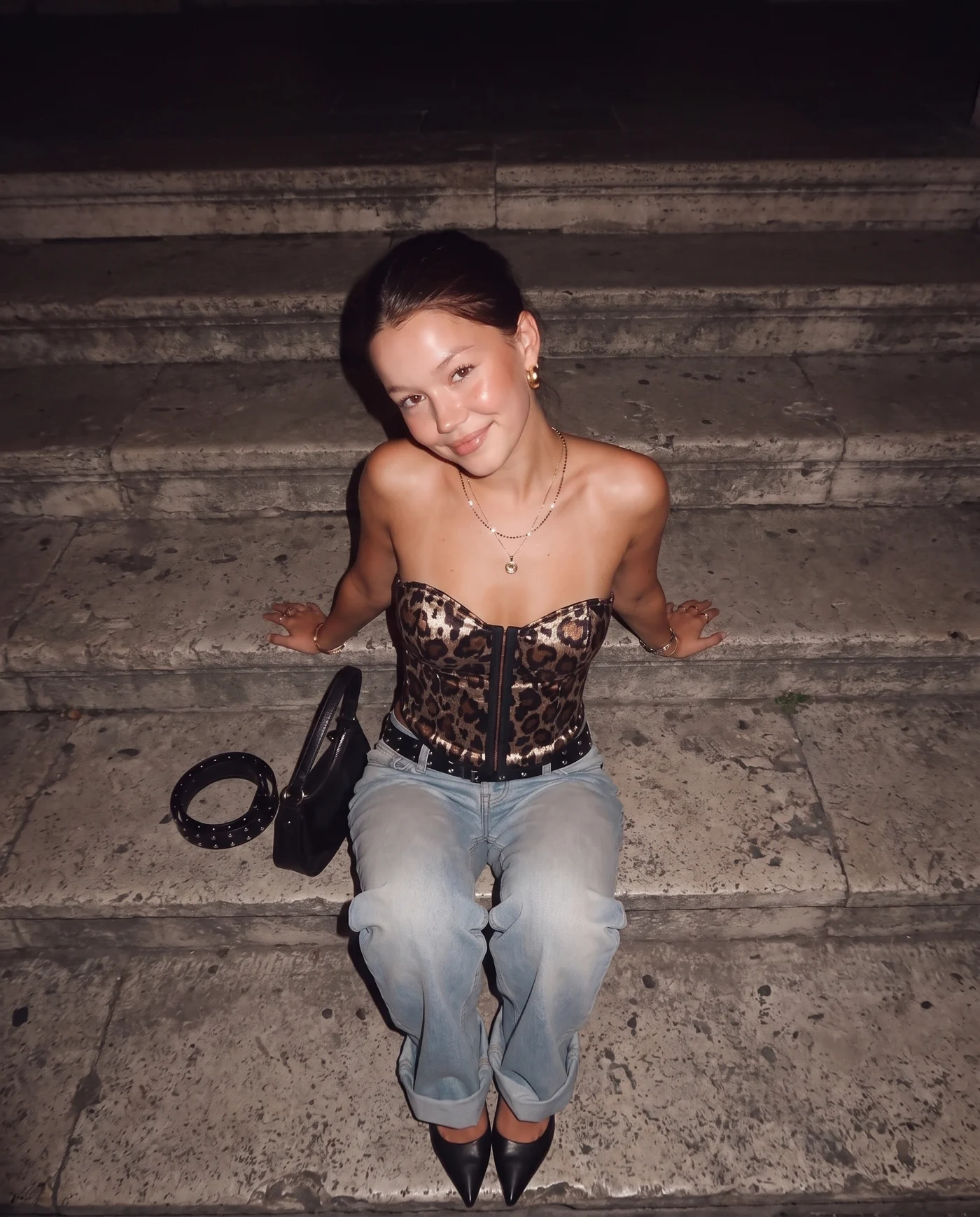 Casuall leopard-print corset — seated on stone steps, shot from above
