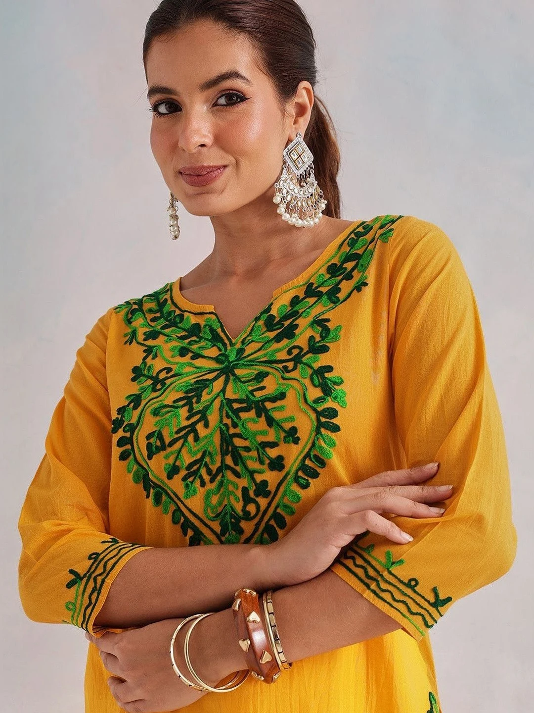 A FEMBLISS yellow kurti with green aari embroidery, shot close