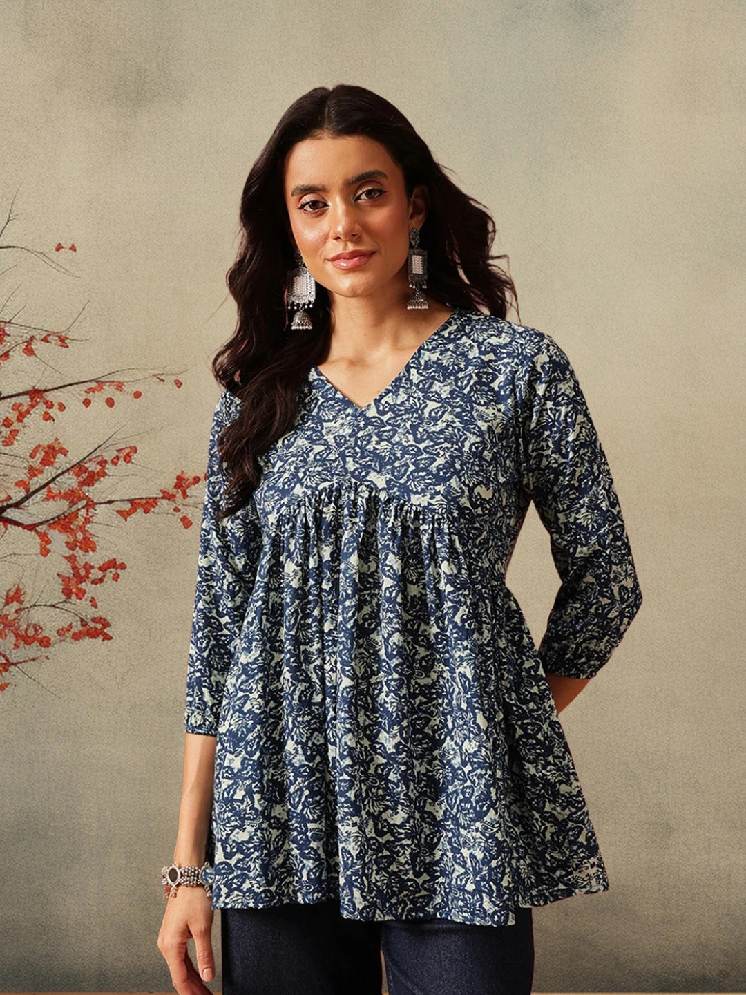 A FEMBLISS blue floral empire kurti shot against a textured wall