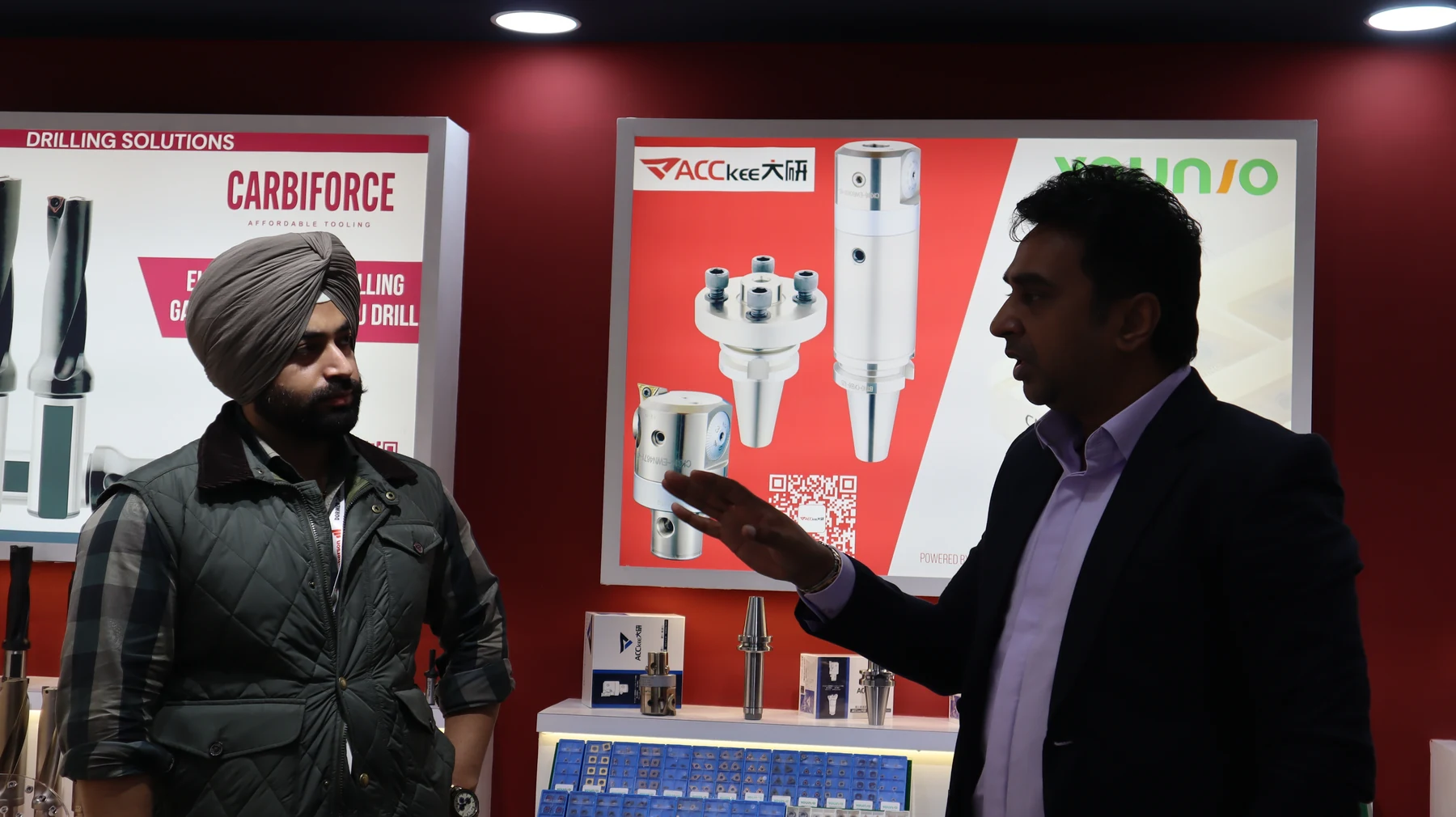 A drilling solutions display being explained to a visitor in front of the product board