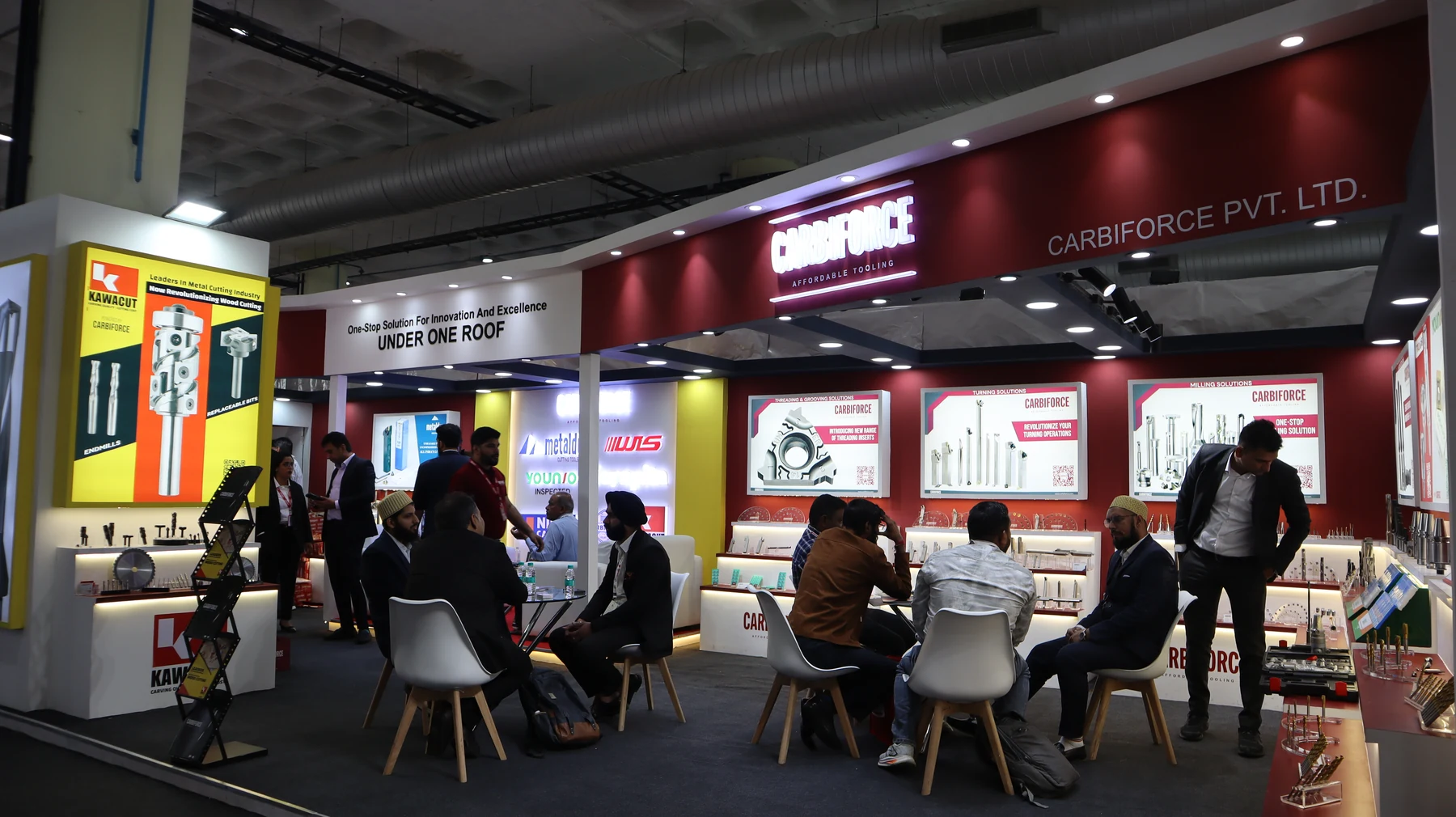 The full Carbiforce stand seen wide, lounge seating in the foreground and visitors throughout