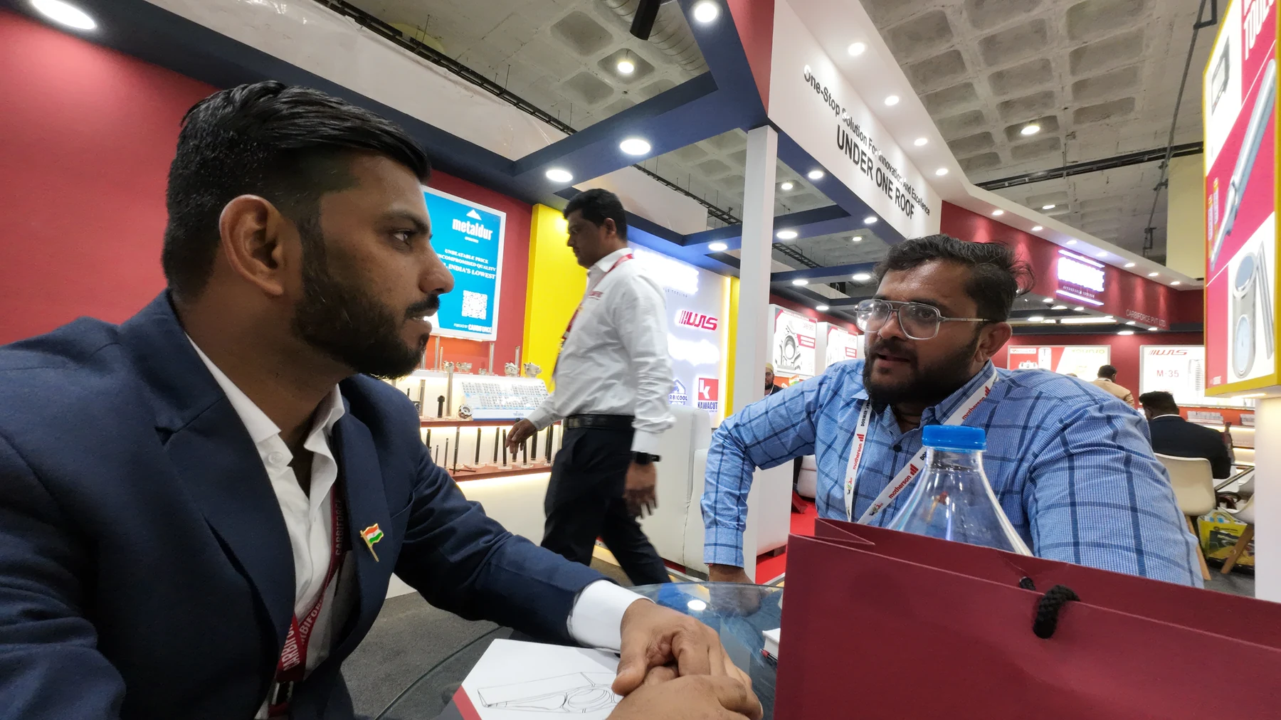 A handshake across the stand counter between a visitor and a member of the Carbiforce team