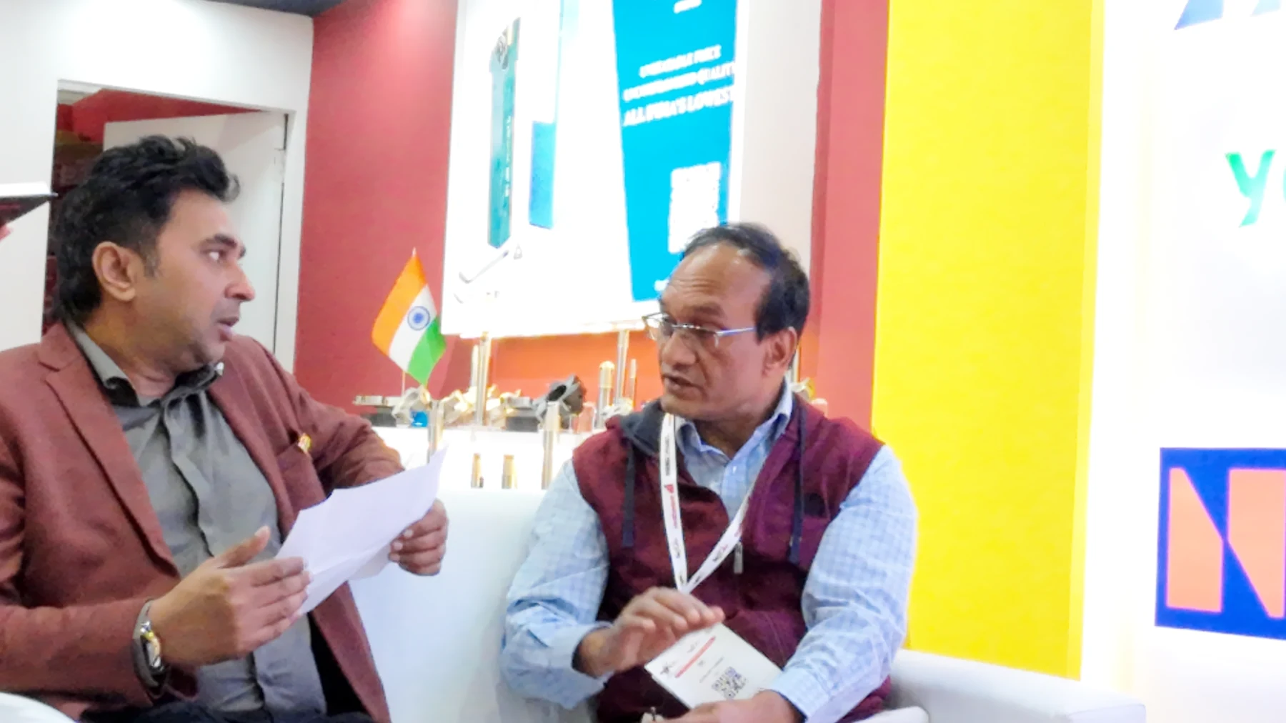 A meeting at the stand with an overseas buyer, product literature on the table between them